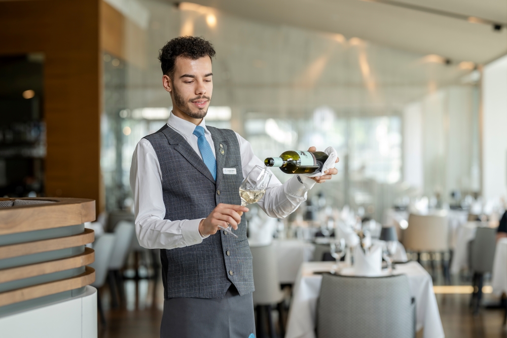web_imlauer_0425-275 web Bild: Kellner im IMLAUER Sky schenkt ein Glas Wein ein